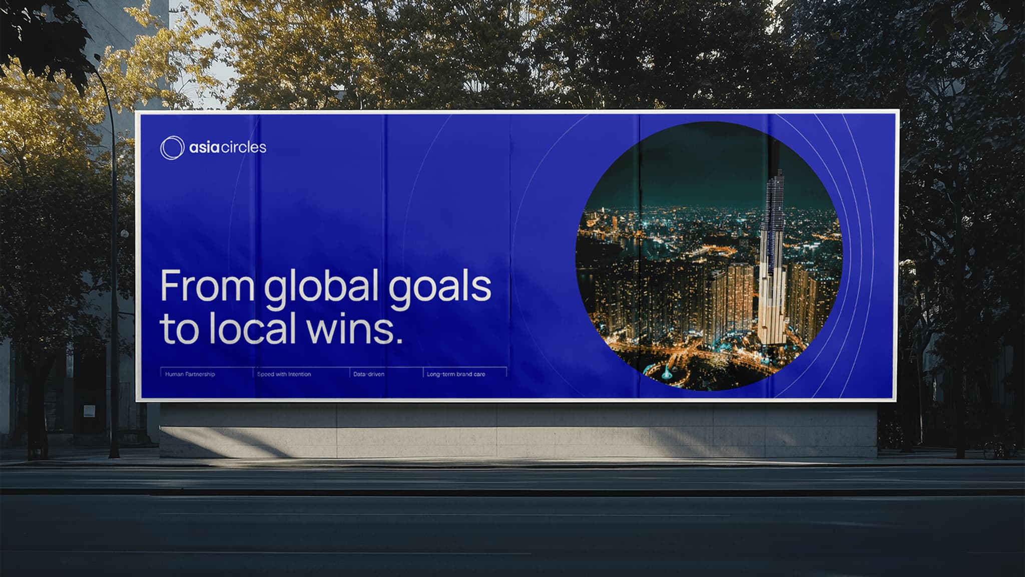 Billboard showcasing "From global goals to local wins" by Asia Circles, featuring a city skyline at night.
