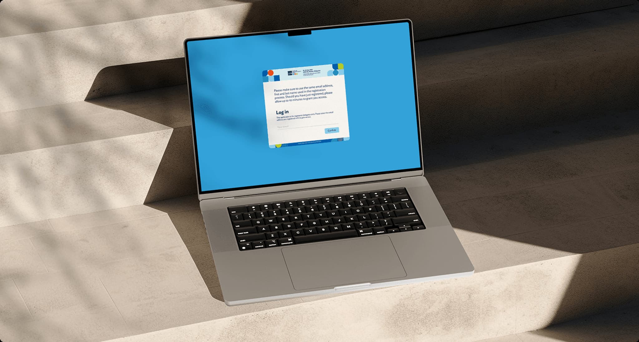 Laptop displaying a digital login registration interface on a blue background, placed on a textured surface.