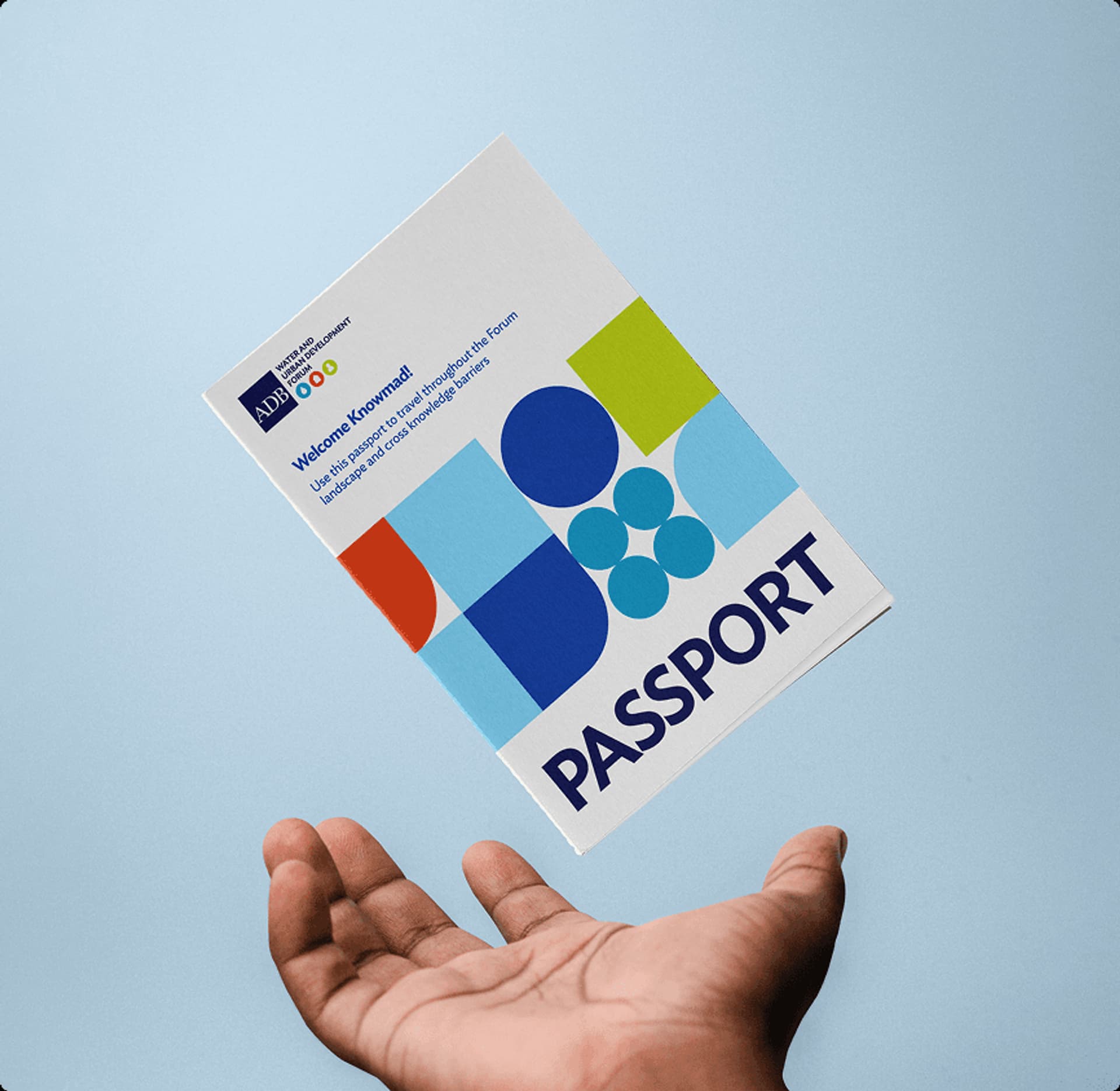 Colorful passport brochure featuring geometric shapes and the word "PASSPORT," held above a hand against a light blue background.