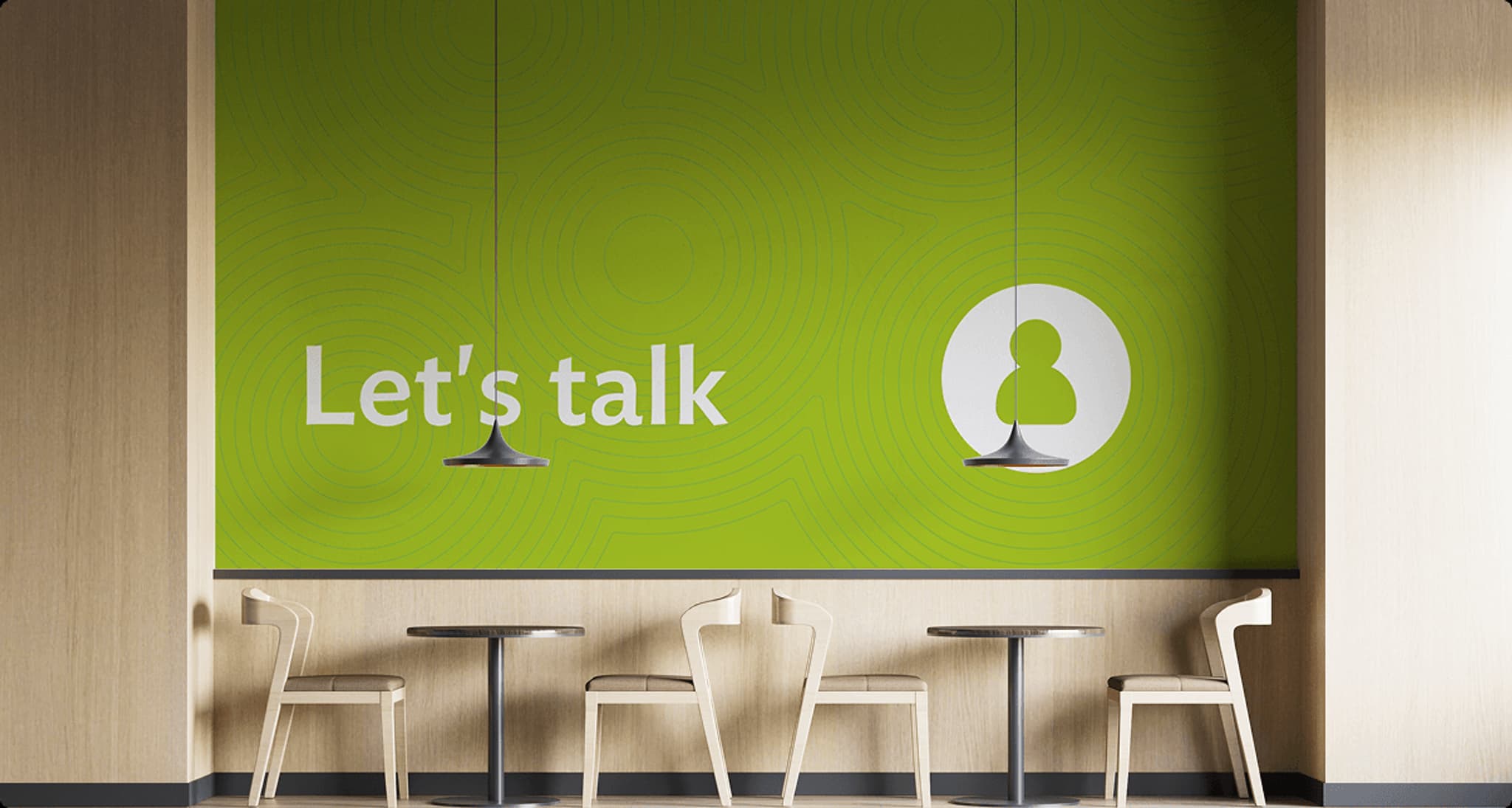 Green wall featuring the text "Let's talk," with modern furniture and pendant lights in a cozy cafe setting.