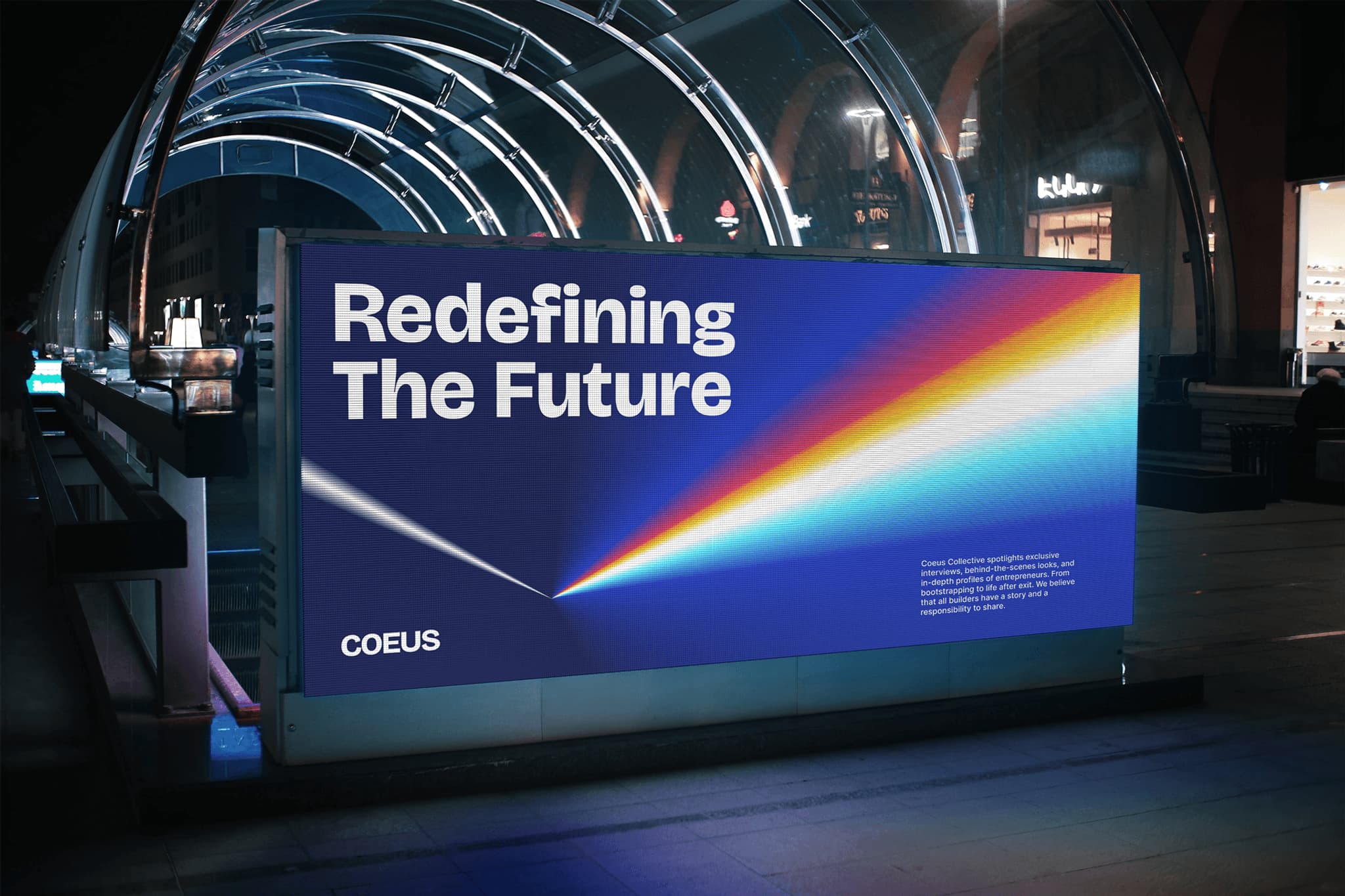 Illuminated billboard displaying "Redefining The Future" with a colorful light beam, branded by COEUS at a modern urban setting.