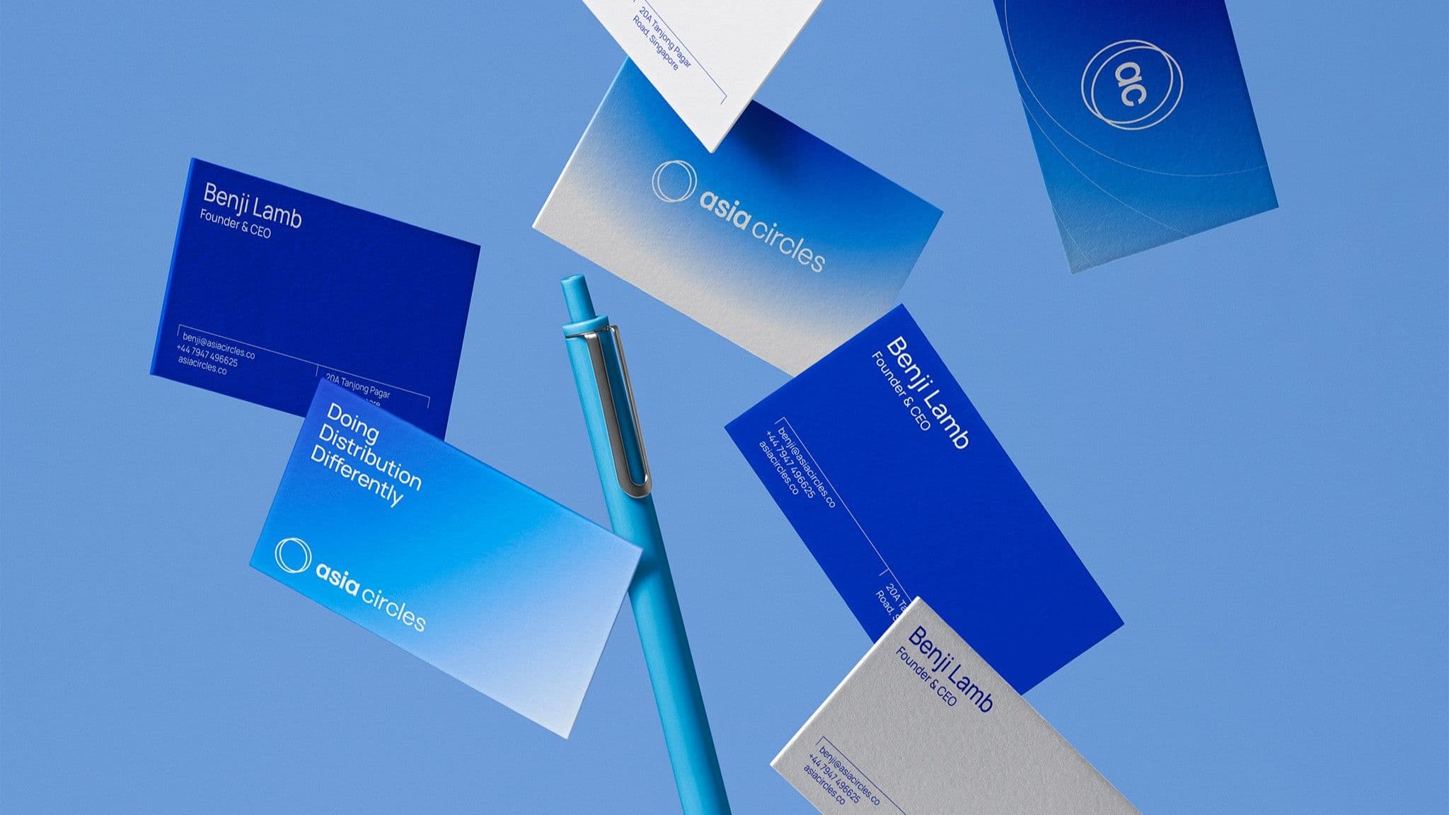 Falling blue business cards with a pen against a light blue background, showcasing professional branding and design.
