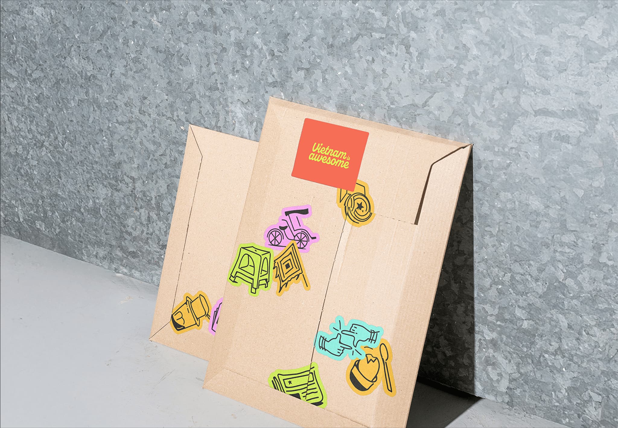 Colorful cardboard box adorned with sketches of toys and household items, set against a textured gray background.